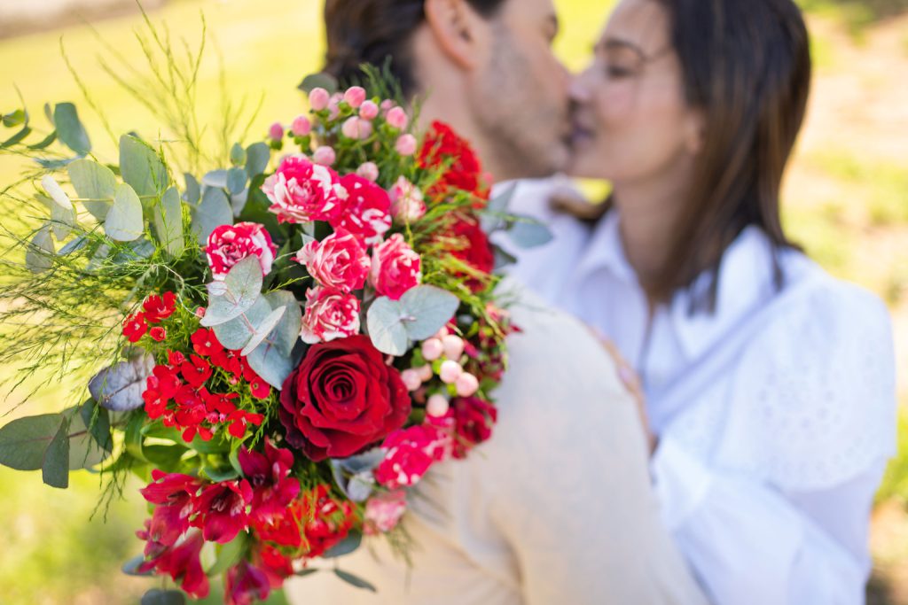 casal-se-beijando-com-buque-de-flores
